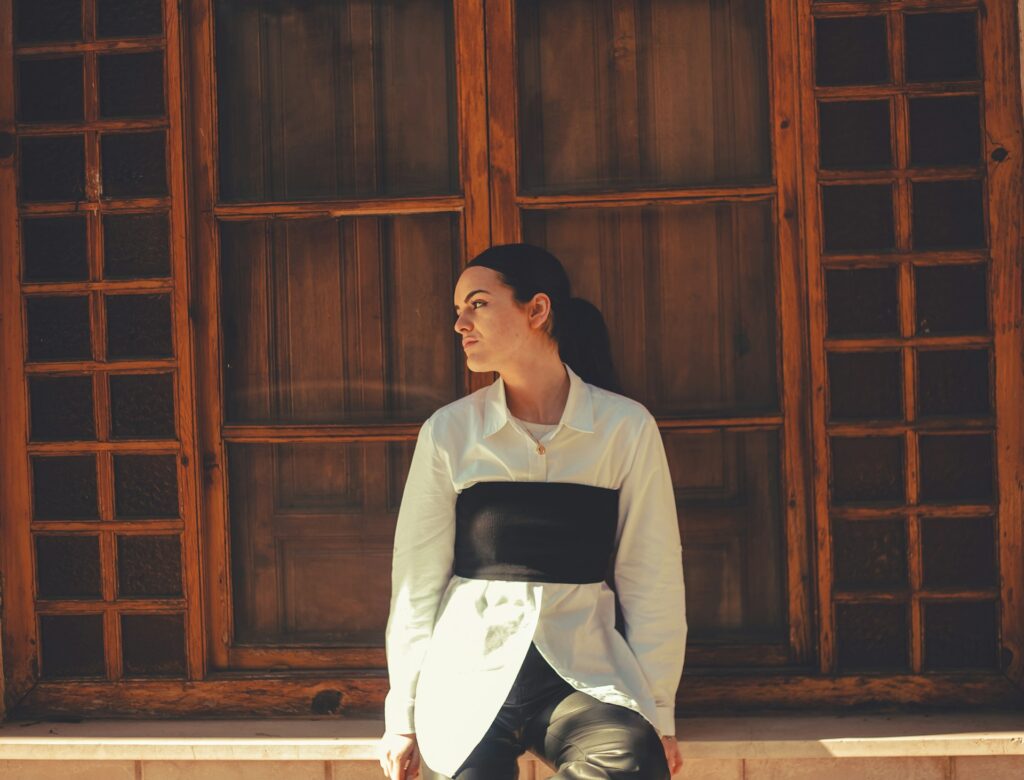 a woman sitting on a ledge in front of a window

