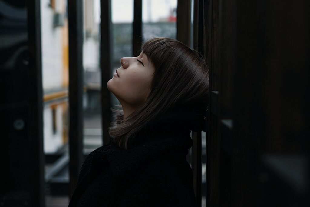 selective focus photography of woman lifting head up with eyes close
