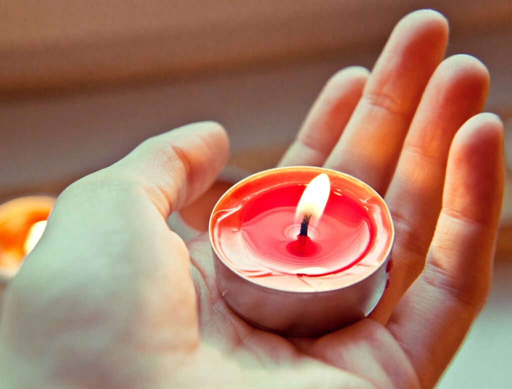 person holding red and white candle

