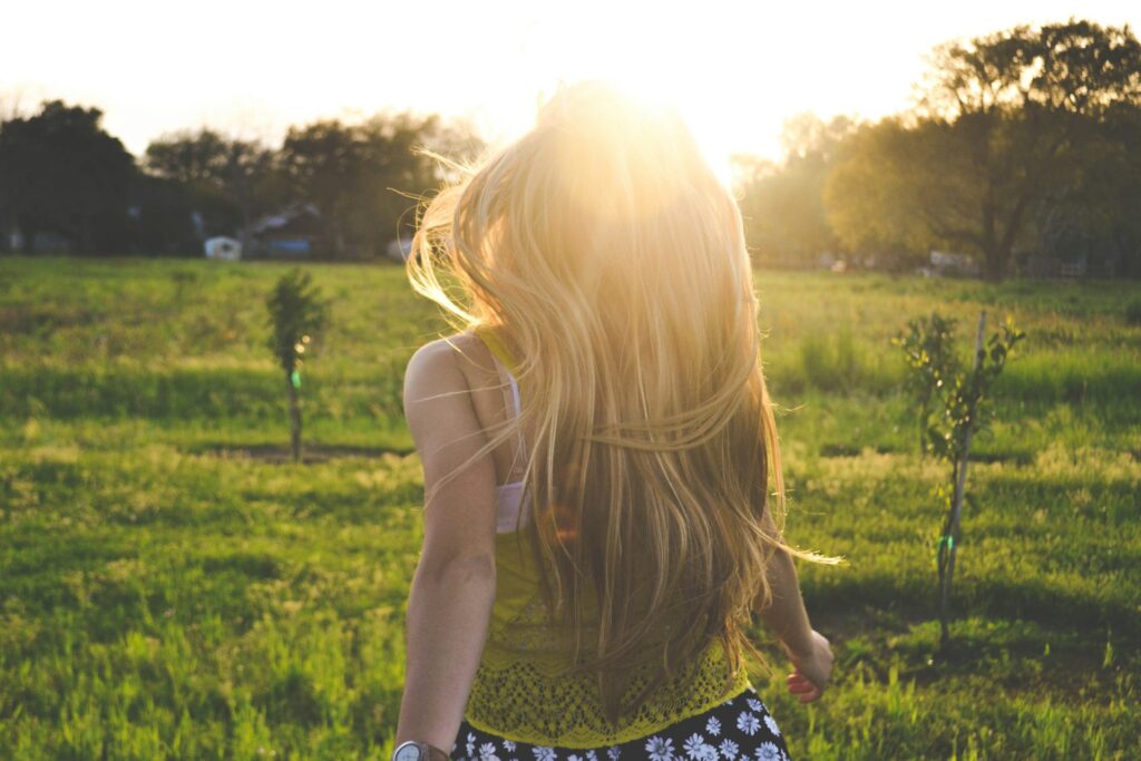 woman walking on lawn with trees
