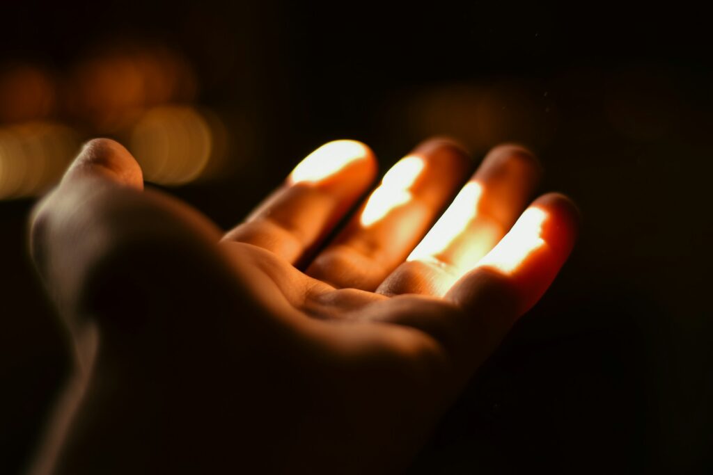A person holding a lit candle in their hand
