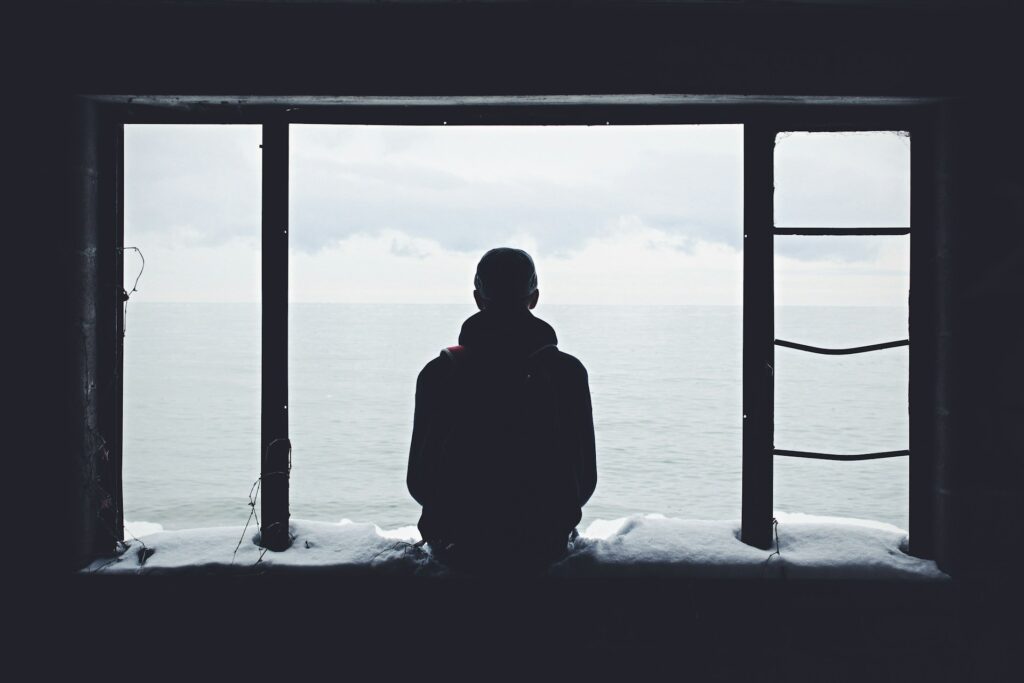 person looking out through window
