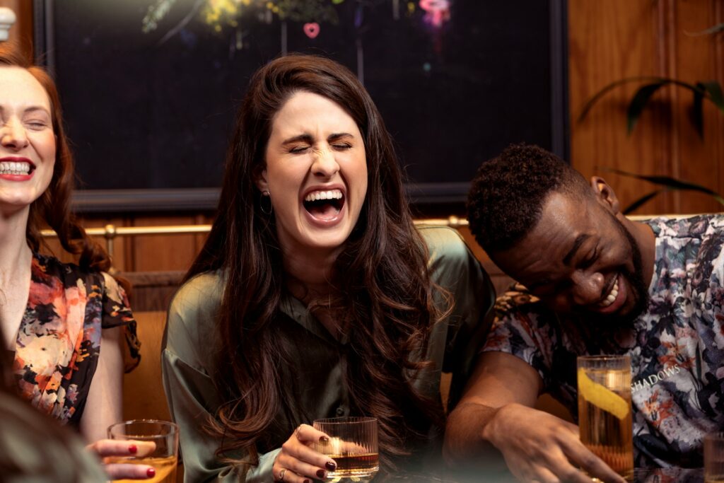 a group of people sitting around a table with drinks
