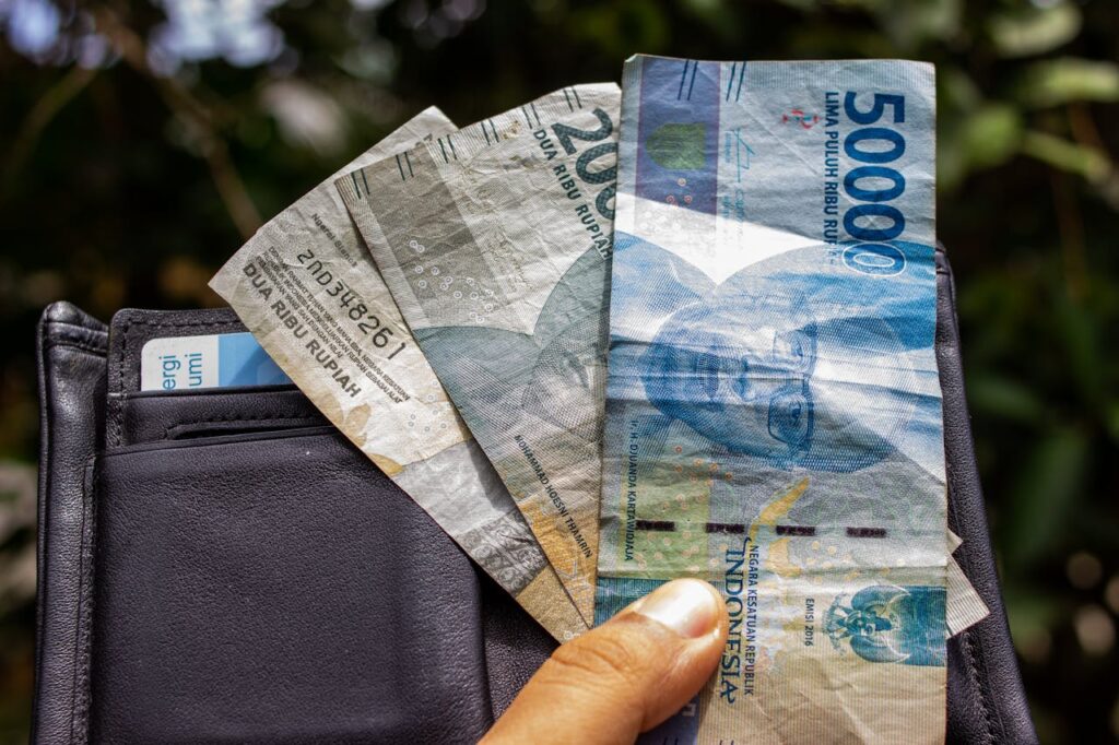 A Person Holding Indonesian Rupiah Paper Money