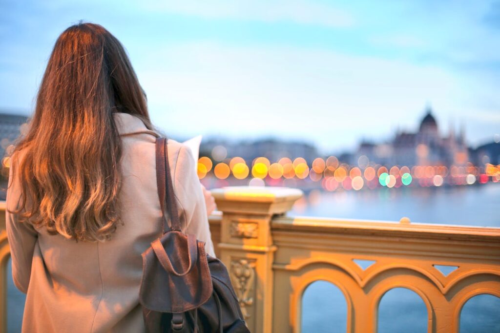 Woman Wearing Trench Coat And Black Leather Backpack
