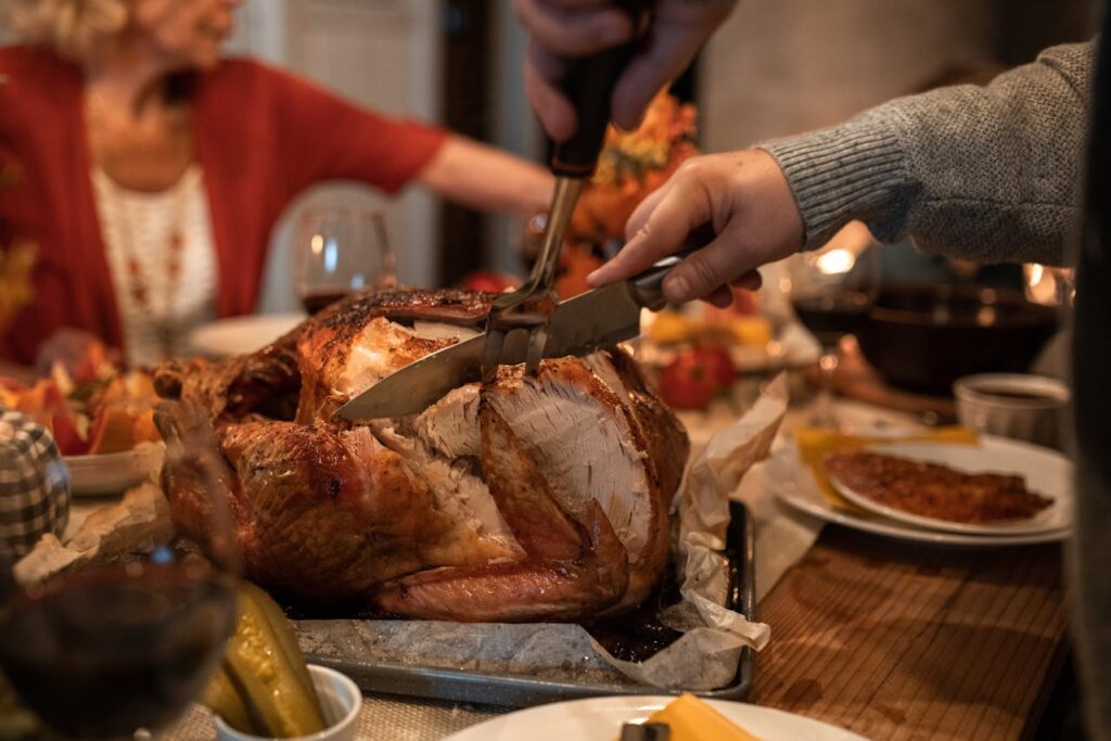 Person Slicing Meat on Table
