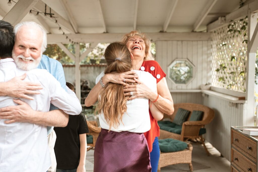 An Elderly Couple Embracing their Son and Daughter
