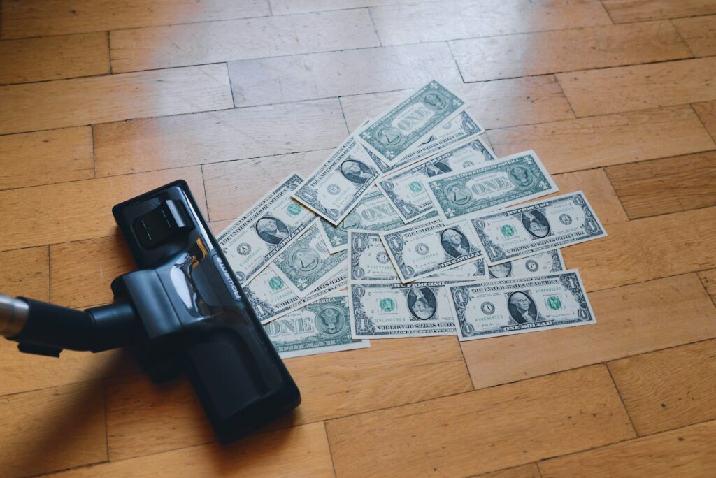 a pile of money sitting on top of a wooden floor
