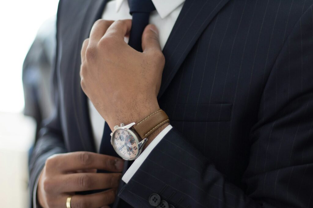 man wearing watch with black suit
