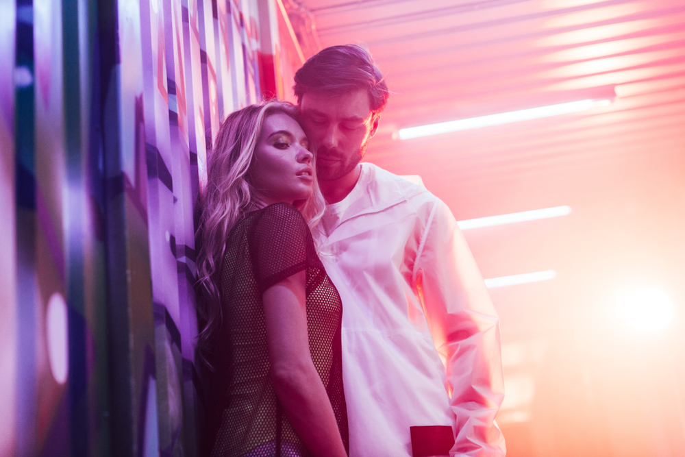 attractive and blonde woman hugging with handsome man in night club