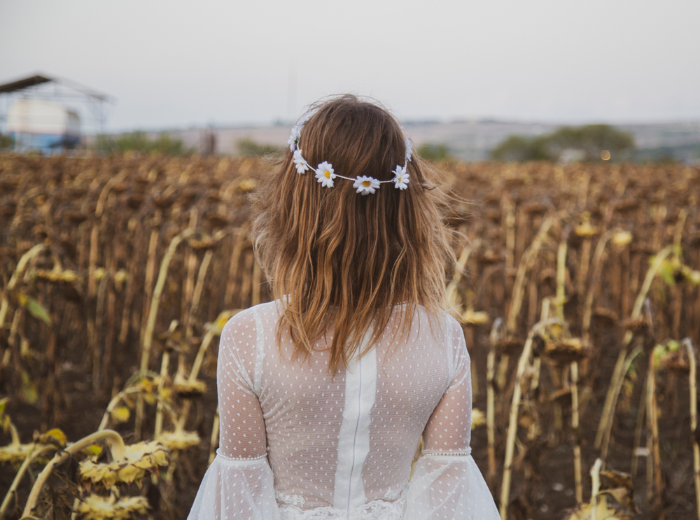 Anonymous back shot of white dressed stylish woman at a field