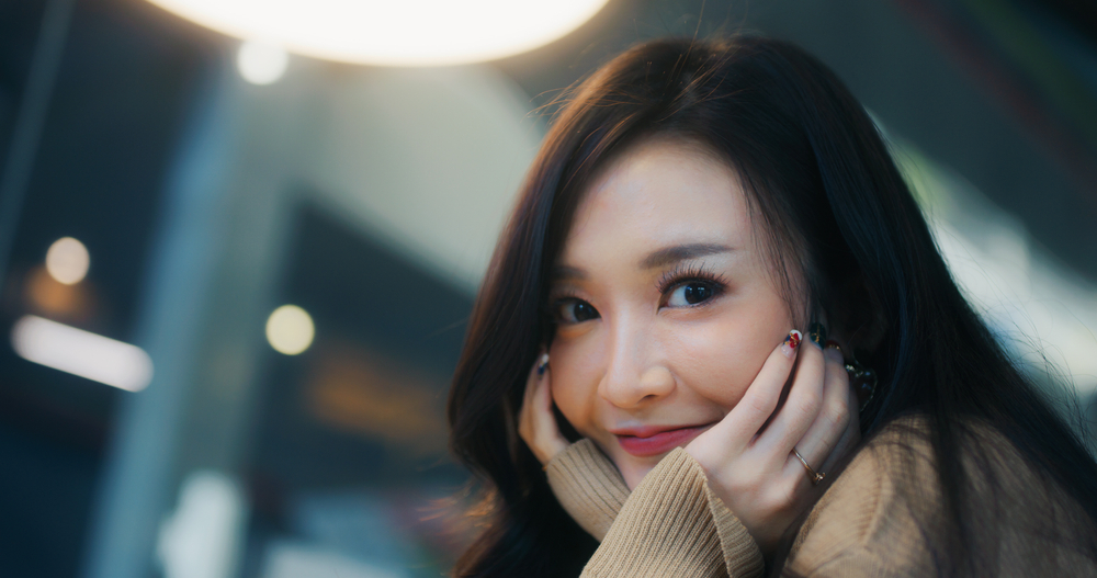 Beautiful young Asian woman smile happily, look at camera, with copy space. People casual leisure, happiness, cafe lifestyle, or cosmetic skincare concept
