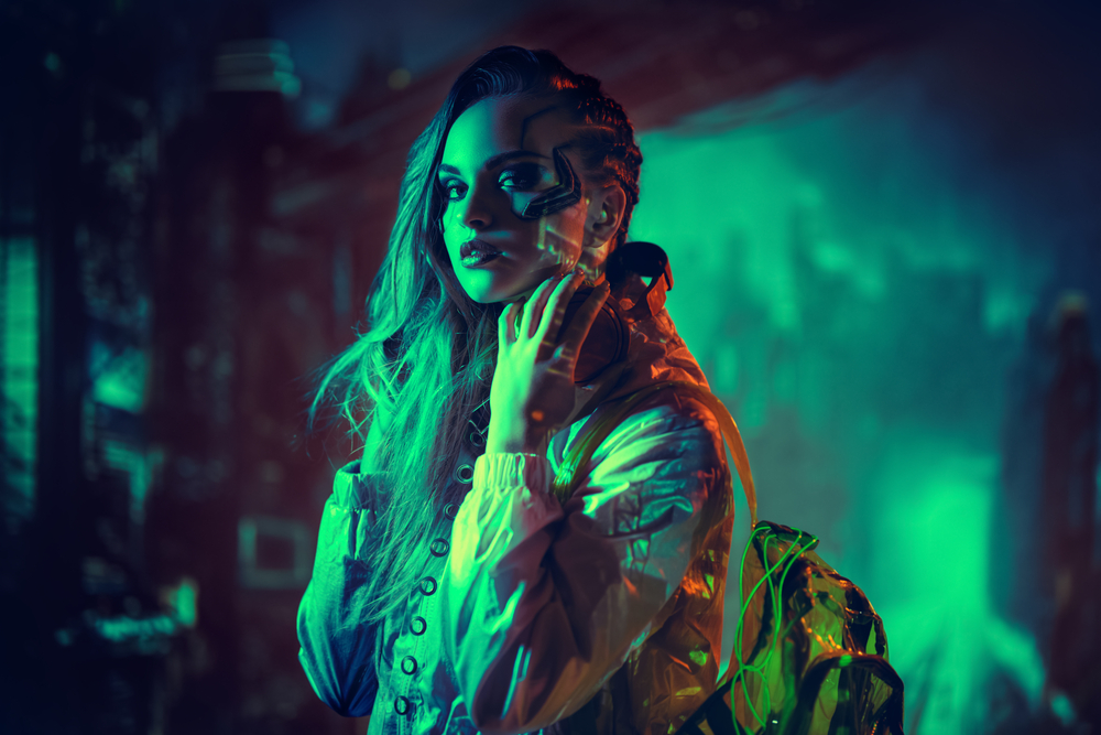 Cyberpunk concept. Portrait of an attractive cyberpunk girl in hi-tech clothes standing in the neon lights of the night city. Game, virtual reality.