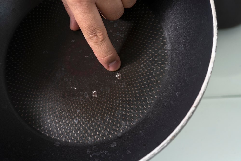 hand shows chips in a non-stick frying pan