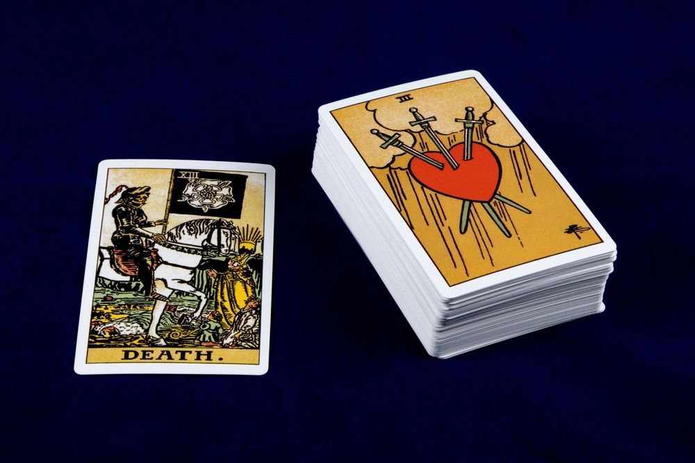 Single tarot card with deck of tarot cards isolated on a dark blue table top