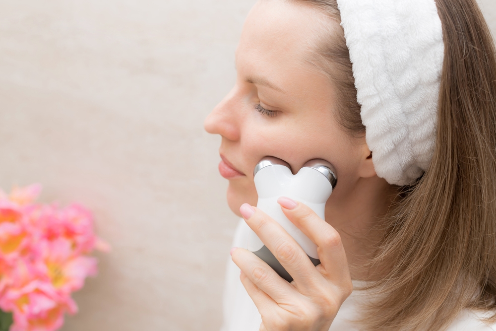woman taking care of her skin with microcurrent facial toning device. Beauty, skincare, cosmetology concept. closeup