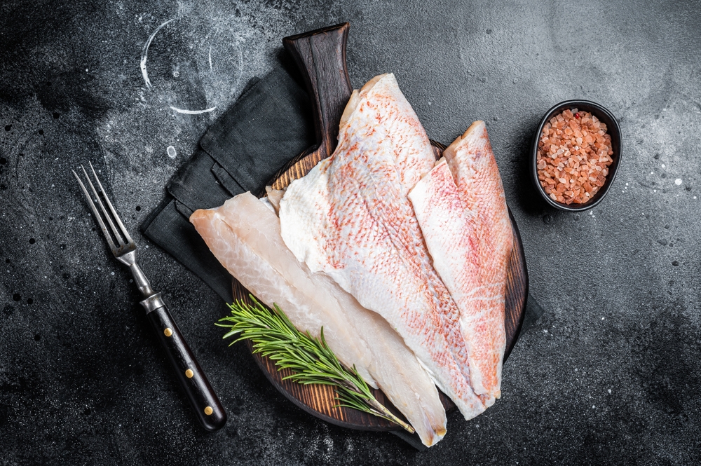 Fresh Raw red perch fillet, Snapper fish on a wooden board. Wooden background. Top view.
