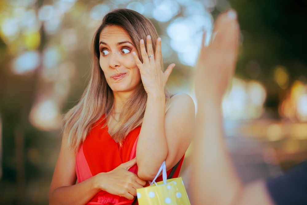 Person Pretending Not to See Someone Waving and Saluting Woman disregarding a friendly greeting after recognizing an annoying acquaintance