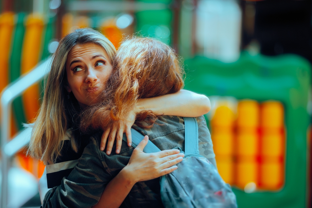 Woman Hugs Fake Friend Making Faces Behind her Back Backstabbing toxic girlfriend embracing someone with bad intentions