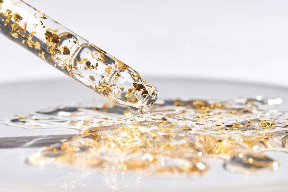 Luxurious gold-infused skincare serum with golden flakes for radiant and rejuvenated skin - beauty and health trends 2023