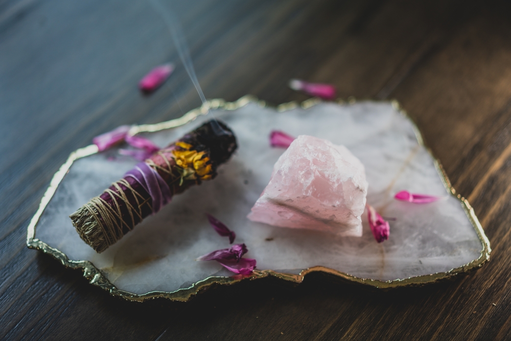 burning sage smudge stick on quartz platter