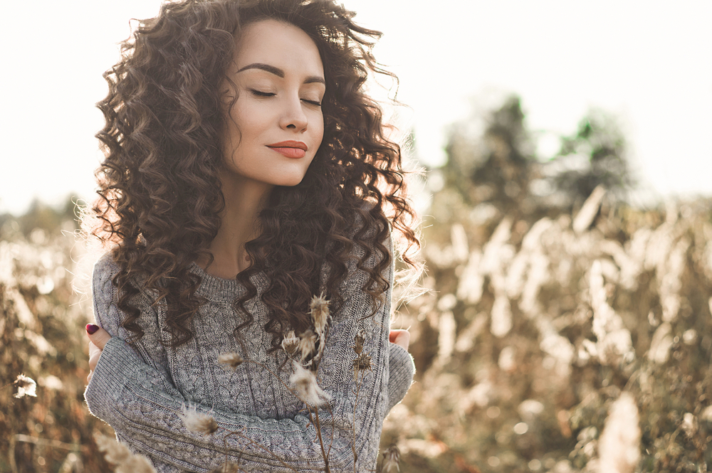 Outdoor atmospheric lifestyle photo of young beautiful lady. Brown hair and eyes. Warm fall. Autumn vibes. Softness, warmth and comfort