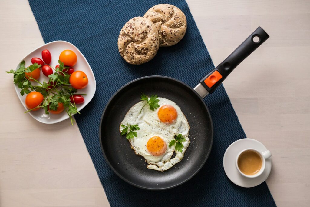 a plate of eggs and a bowl of tomatoes on a table