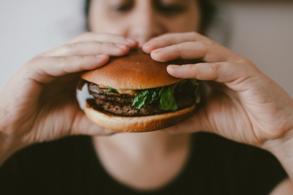 person holding burger
