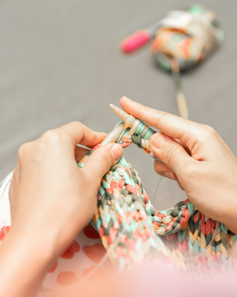 a woman is knitting a piece of fabric
