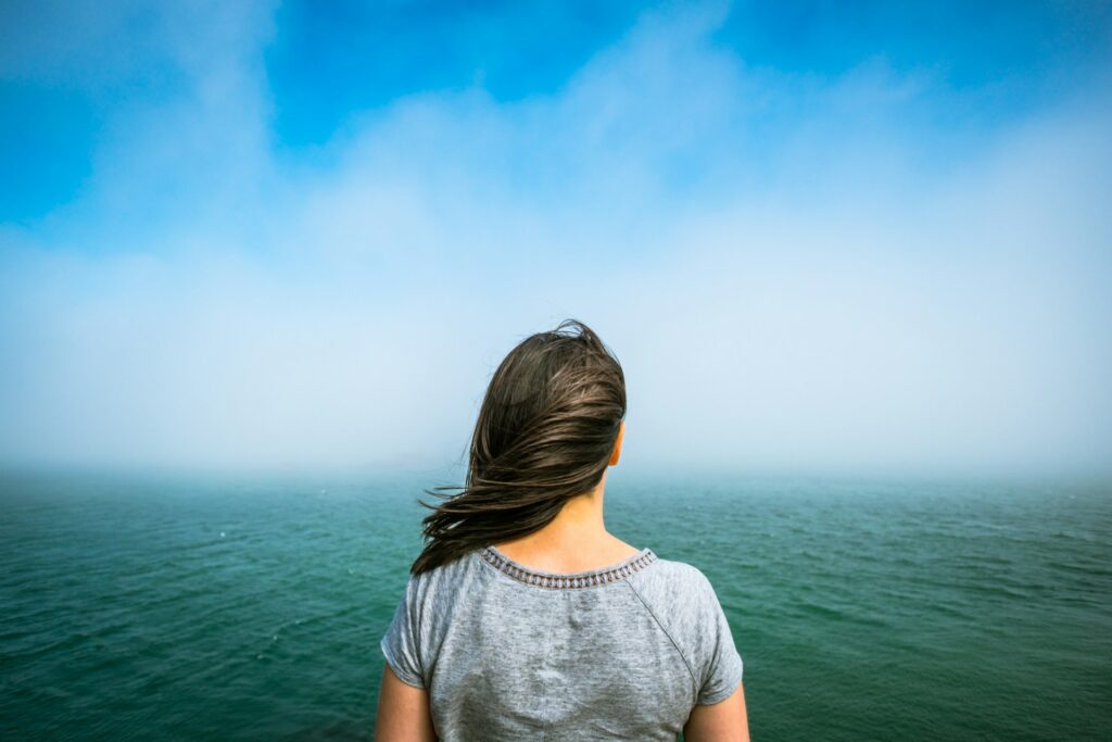 woman standing near the body of water
