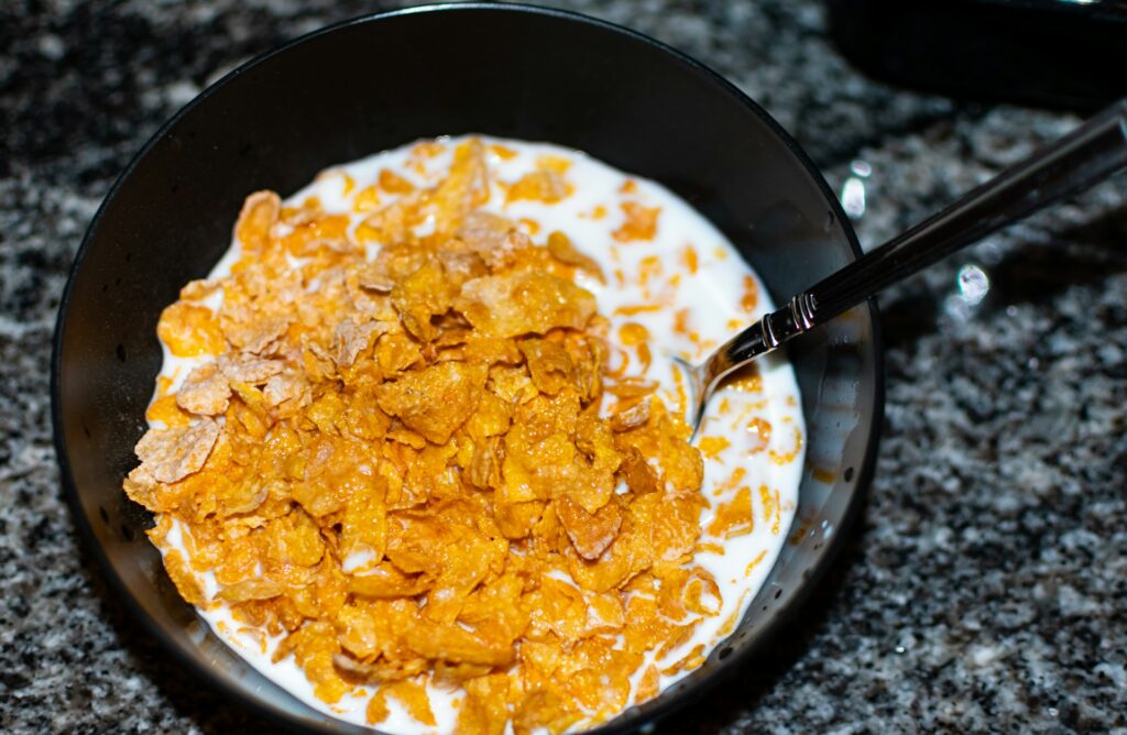 Cornflakes and milk sit in a bowl.
