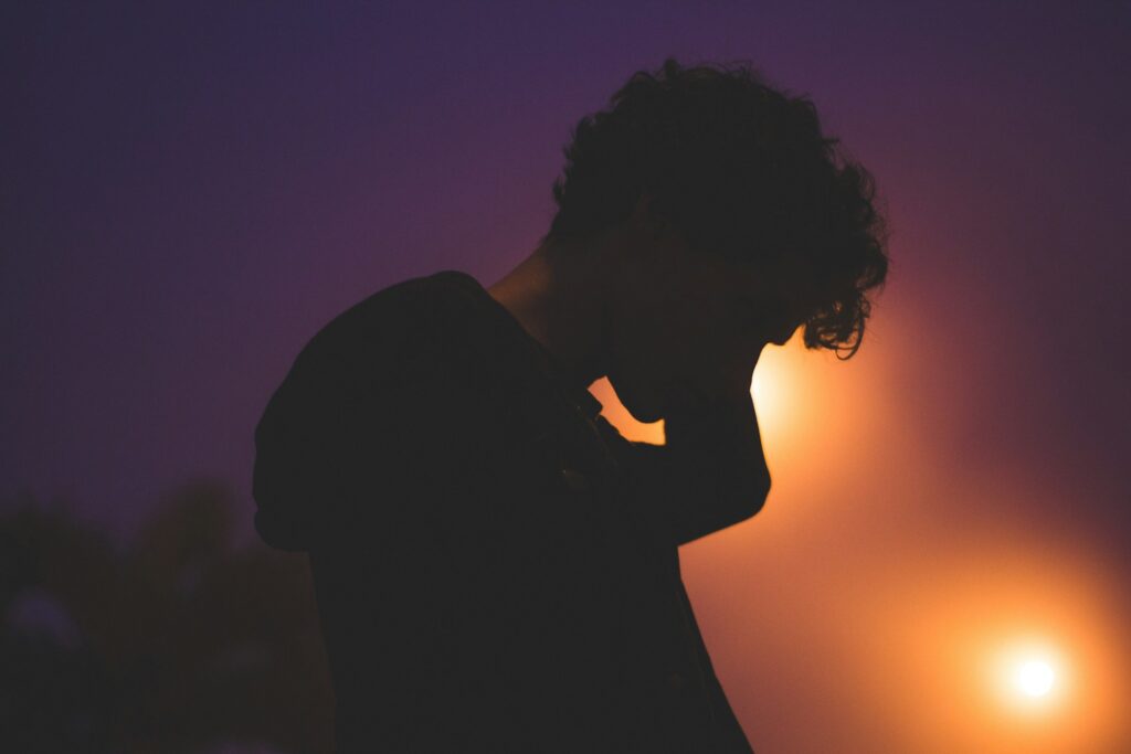 silhouette of man with light on his face
