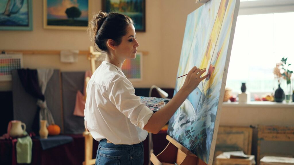 A woman paints a picture in her art studio.

