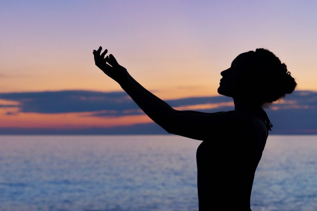 silhouette of woman raising her right hand
