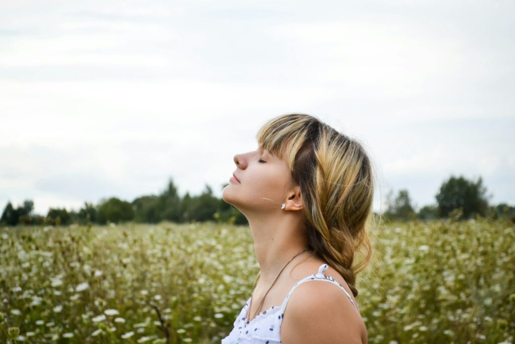 a woman standing in a field of tall grass
