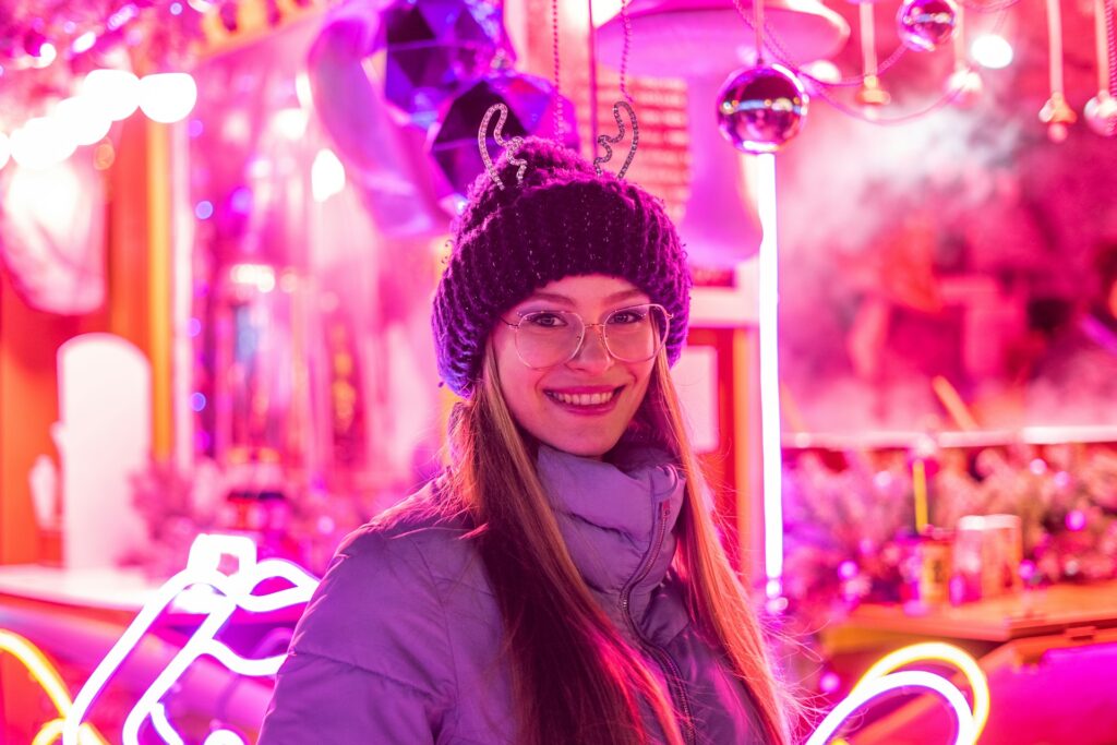 a woman standing in front of a purple light
