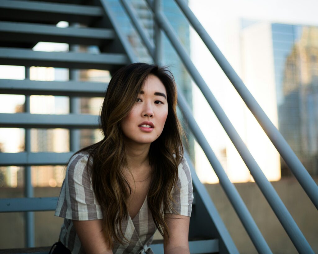 woman sitting on white metal stairs

