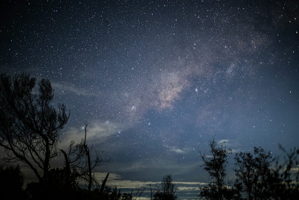 Stars and milky way shine brightly in the night sky.