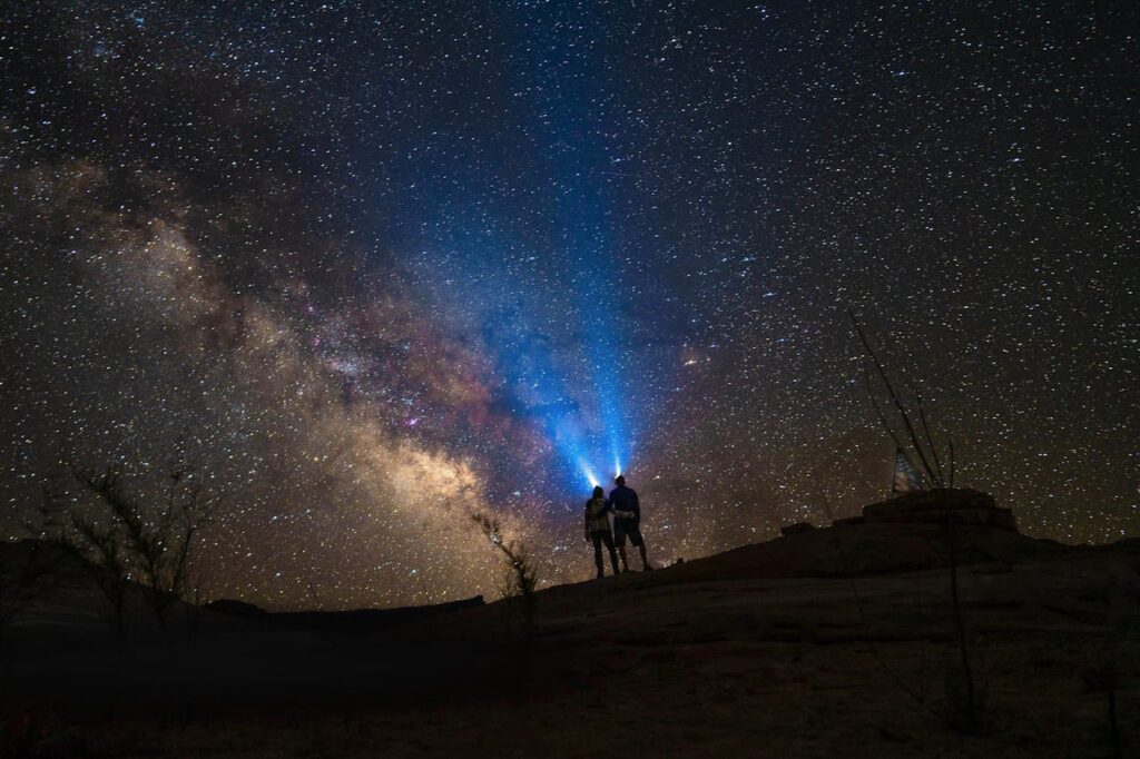 Silhouette Couple with Torches Standing Under Starry Night