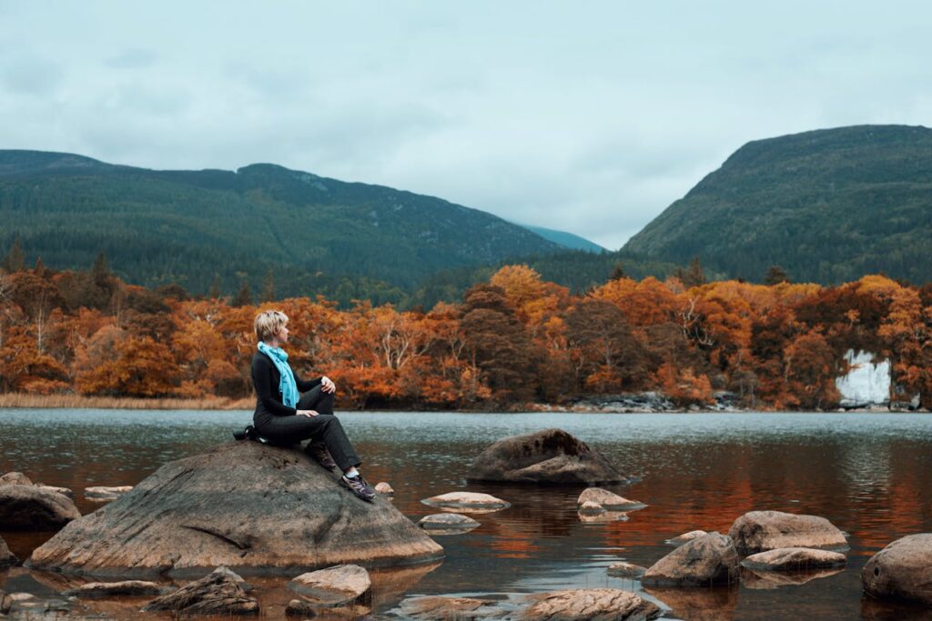 Woman Sitting on Rock Near River
