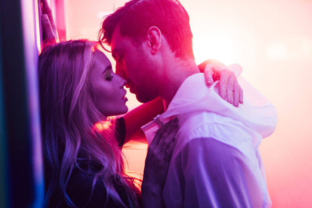 side view of attractive and blonde woman hugging and kissing with handsome man