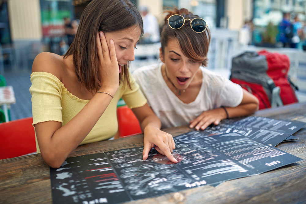 Two friends ordering in a cafe together from menu