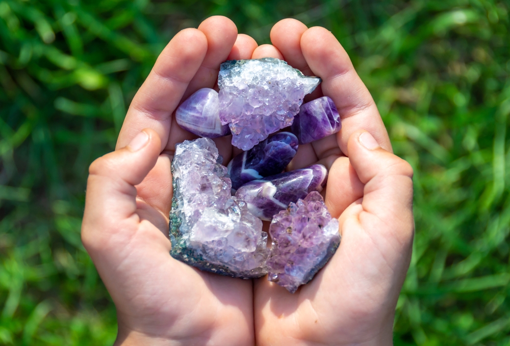 Natural mineral amethyst in hand. Semi-precious multi-colored stones, minerals close-up. Mineralogy. Collection of minerals.