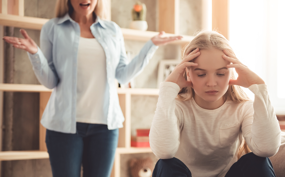 Beautiful woman is scolding her teenage daughter, girl is ignoring her mom