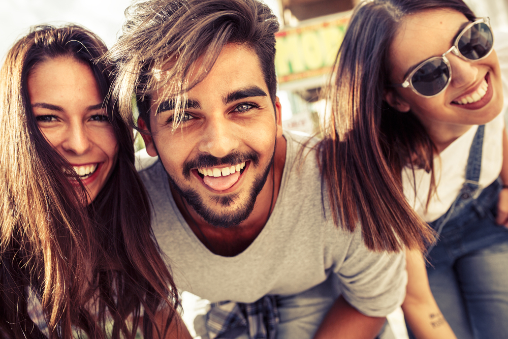 Group of happy young friends having fun on city street.Sunset.Close up image.