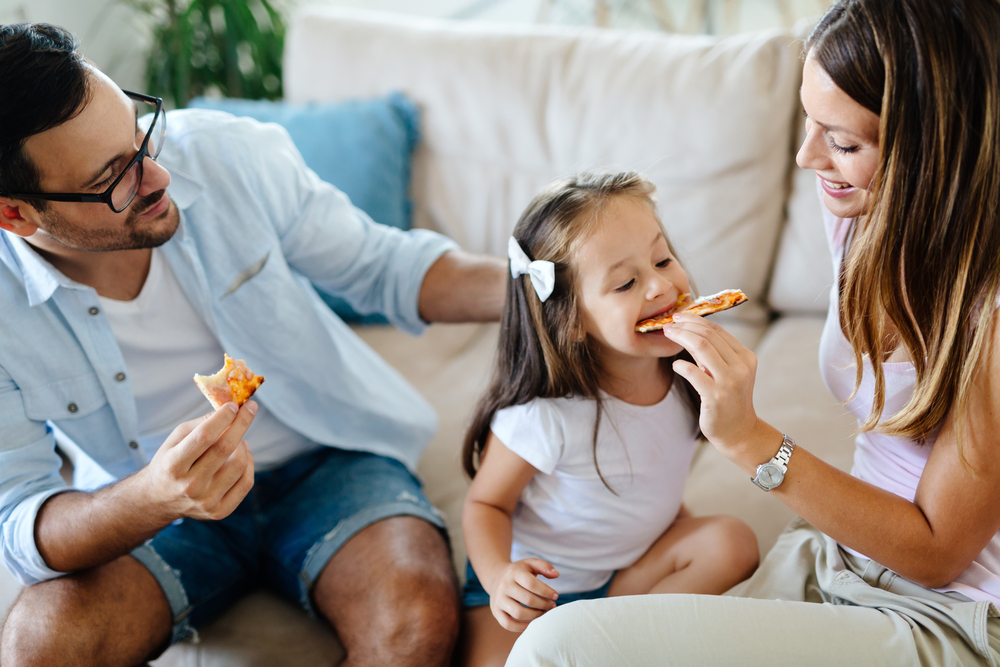 Happy family sharing pizza together at home