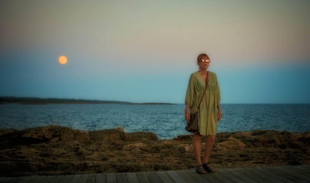a woman standing on a dock near the ocean
