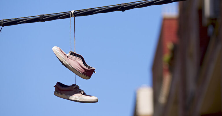 The Real Reasons You Sometimes See Shoes Dangling From Power Lines - Featured image