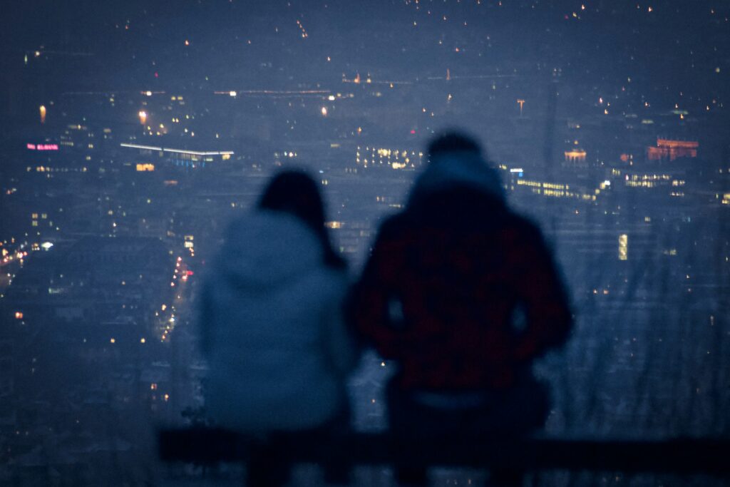 man and woman sitting on bench during night time
