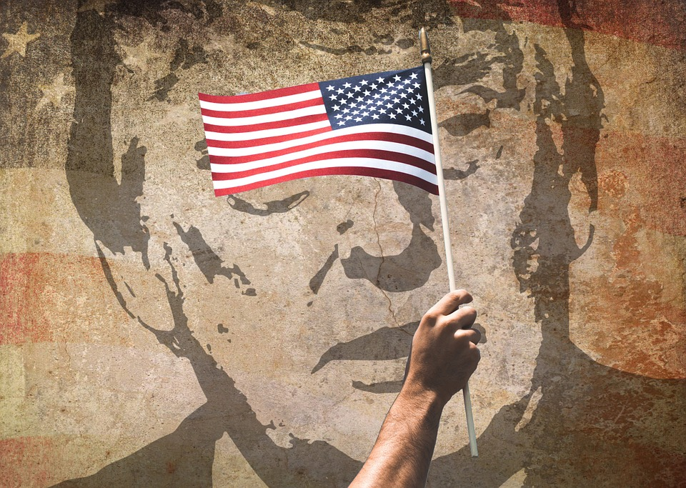 Trump superimposed onto a wall with a flag flown across his face.
